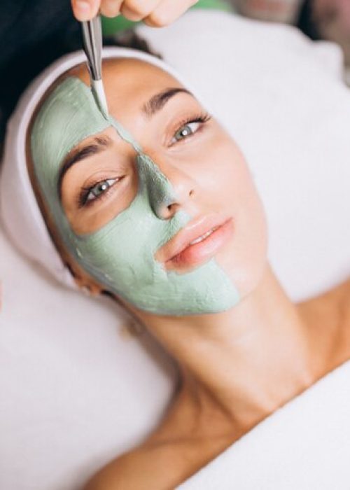 cosmetologist-applying-mask-face-client-beauty-salon_1303-16755